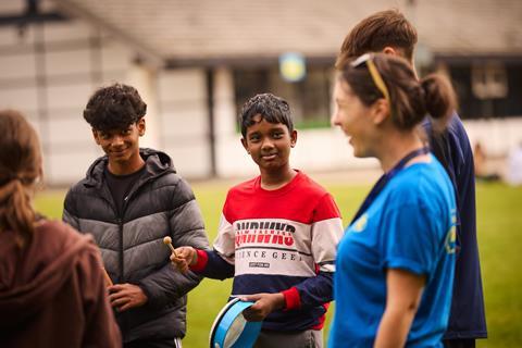 Children are led in an activity by a PGL instructor