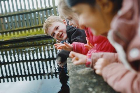 Children peer into the water - they're illustrating the offer from the Council for Learning Outside the Classroom which is giving away free membership to schools and educational settings