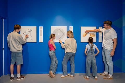 A family look at illusion drawings on a wall
