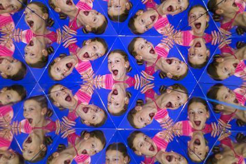 A girl looks into a mirror prism