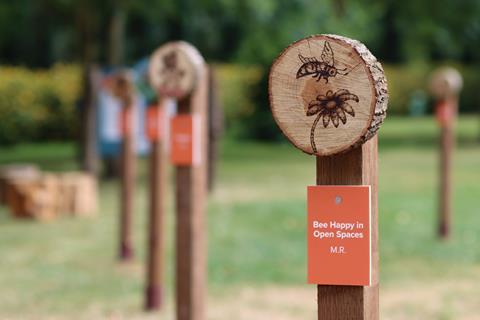 A wooden pole with a log round decorated with a bee