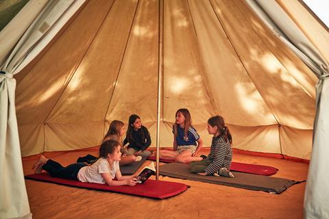 Children relaxing in a teepee