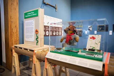 An exhibition display featuring a womble toy and a poppy artwork