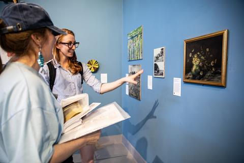 Two women looking at a painting in a gallery