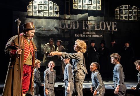 Oliver asks Mr Bumble for more gruel in the 2025 West End production of Oliver!